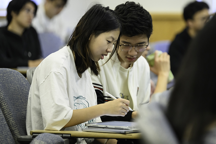A student helping another student in class.