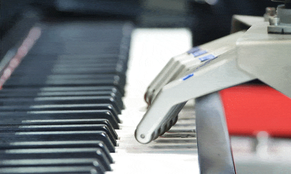 A gif of a robotic arm playing the piano.