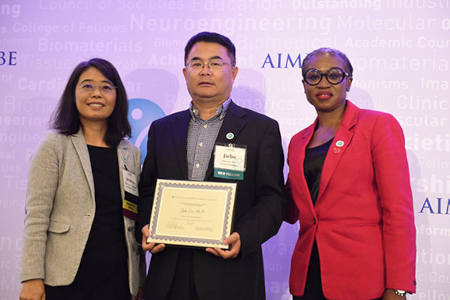 Jiebo Luo holding award flanked by two presenters