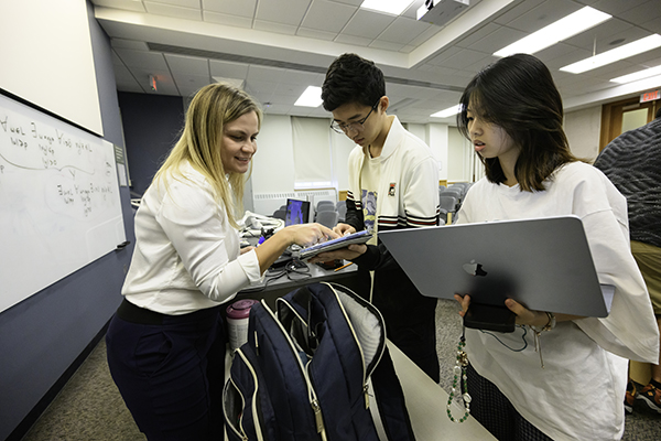 A professor and TA helping a student.